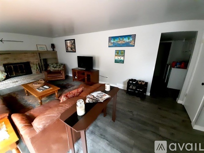 A living room with a brown leather couch and a wooden coffee table.