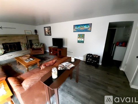 A living room with a brown leather couch and a wooden coffee table.