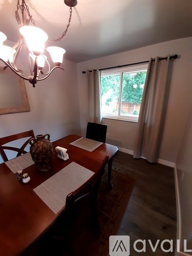 A dining room with a wooden table and chairs.
