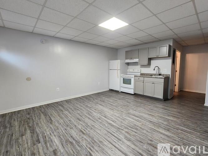 A kitchen area with a white refrigerator, microwave, and cabinets.