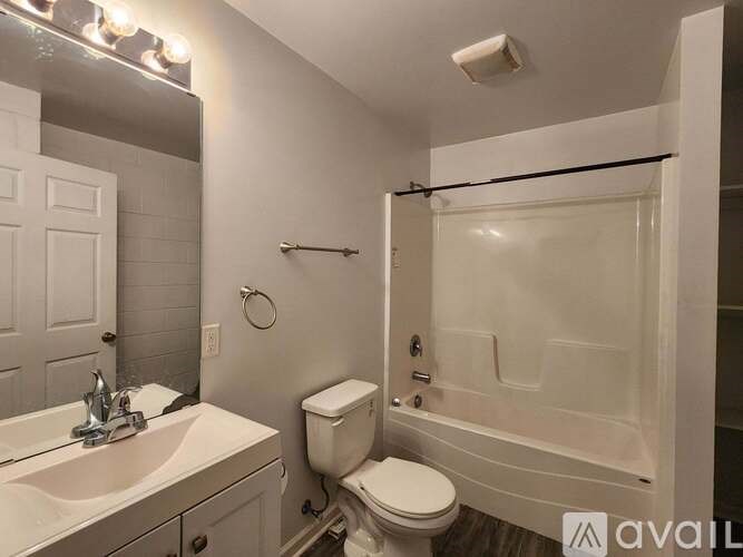 A bathroom with a toilet, sink, and shower.