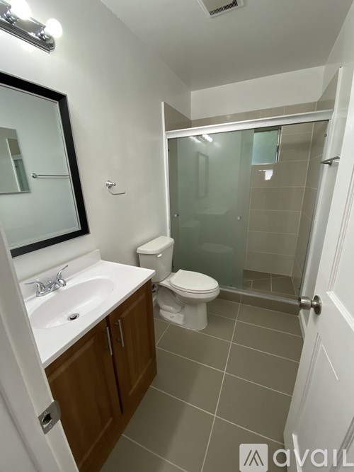 A bathroom with a toilet, sink, and shower.
