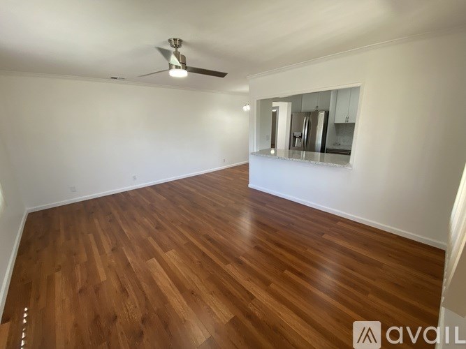 A room with wooden flooring and a ceiling fan.