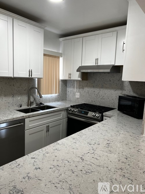 A kitchen with granite countertops and white cabinets.