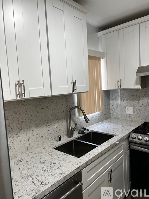 A kitchen with granite countertops and white cabinets.