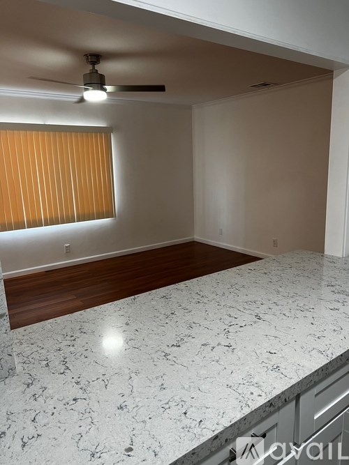 A kitchen with a marble countertop and a ceiling fan.