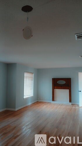 A room with a wooden floor and a window.