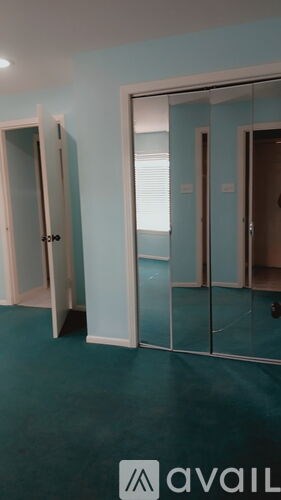 A hallway with a glass door and a white door.