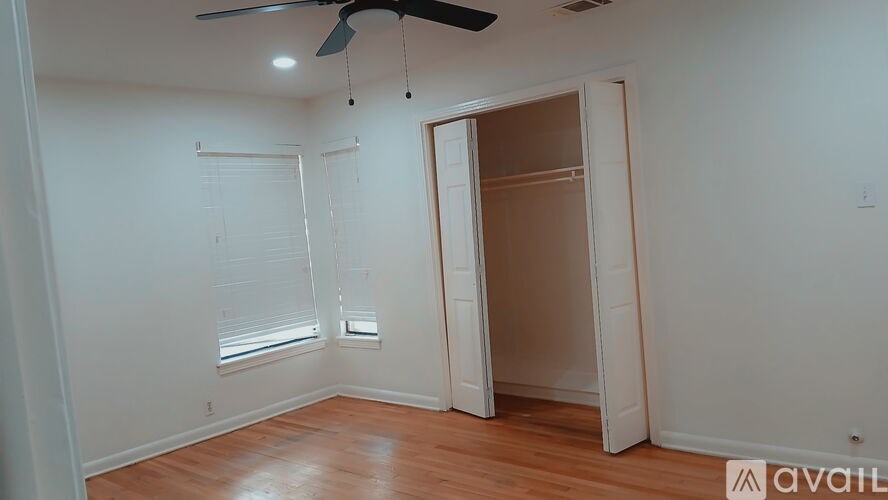 A room with a ceiling fan and a door leading to another room.