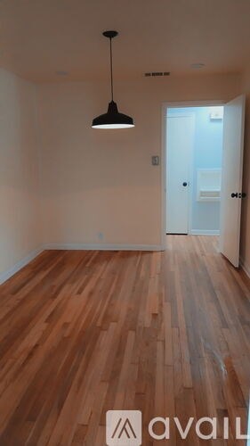 A room with wooden floors and a light hanging from the ceiling.
