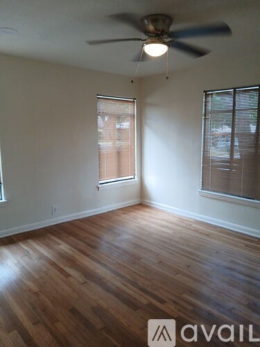 A room with wooden floors and a ceiling fan.