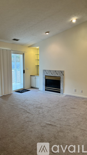 A living room with a fireplace and a large window.