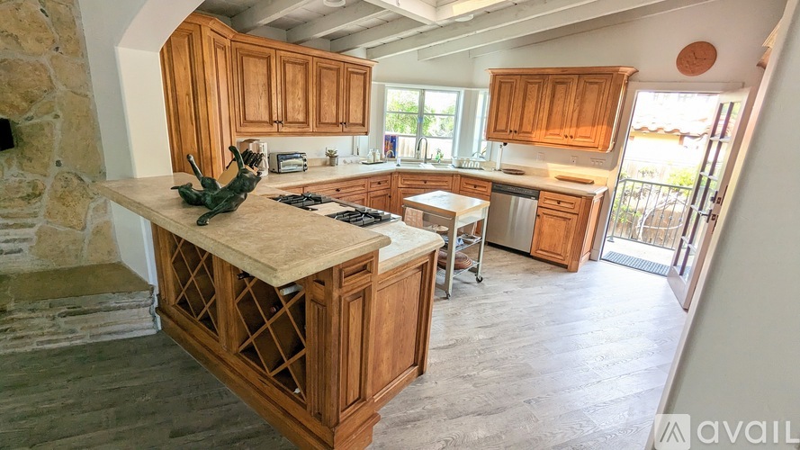 A kitchen with wooden cabinets and a stone fireplace.