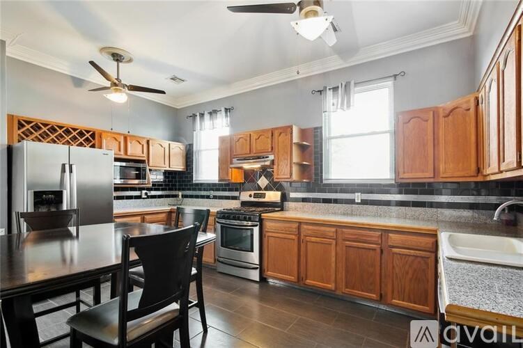 A kitchen with wooden cabinets and a black chair.
