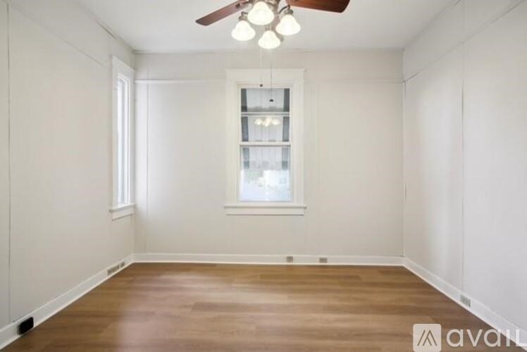 A room with a ceiling fan and a window.