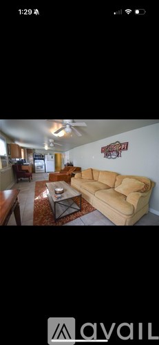 A two-story house with a red roof and a balcony on the second floor.