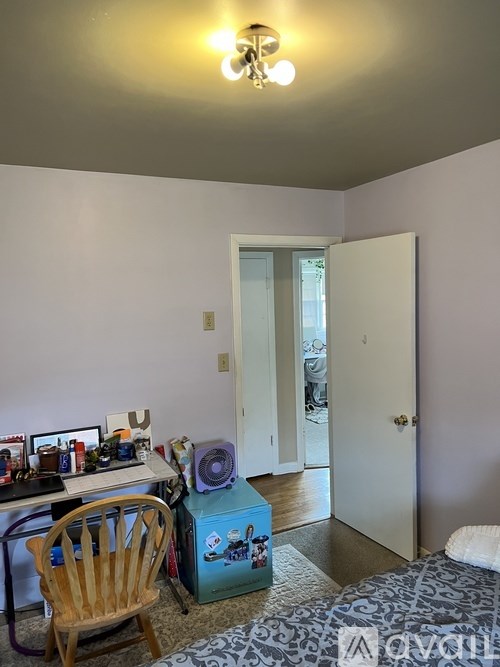 A room with a bed, a desk with a computer, and a chair.