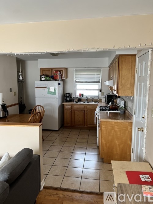 A kitchen with a refrigerator, sink, and cabinets.
