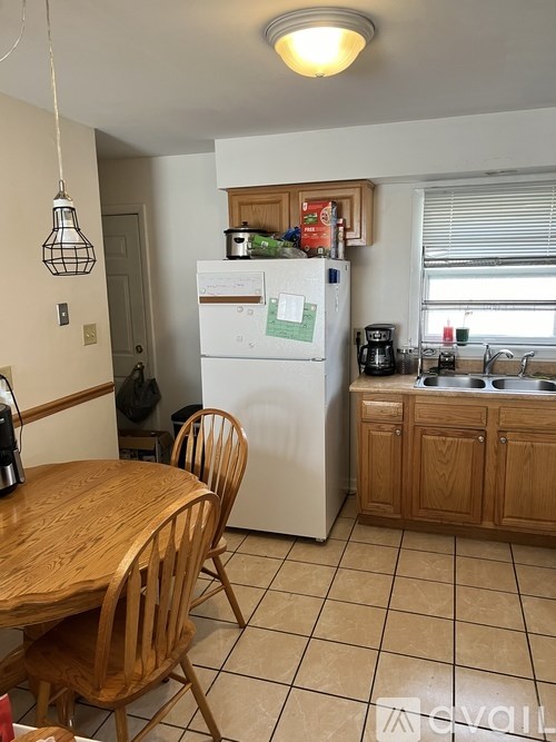A kitchen with a wooden table and chairs.