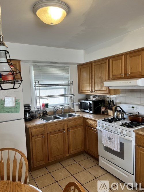 A kitchen with wooden cabinets and a white stove top oven.