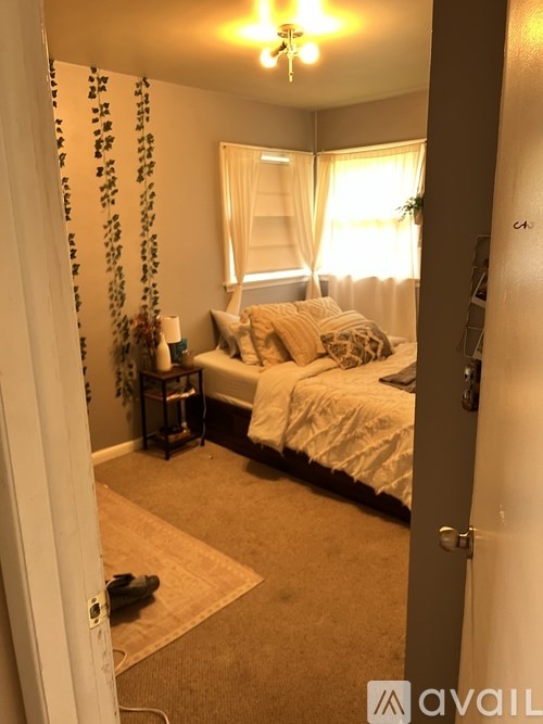 A bedroom with a bed, nightstand, and window.