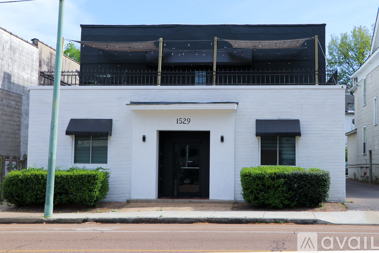 A white building with black awnings and a black door.