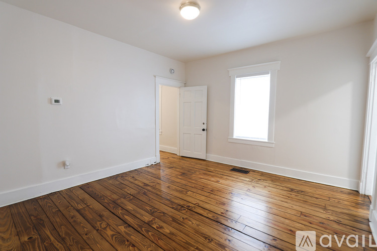 A room with wooden floors and a white door.