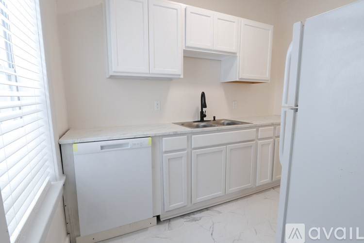 A kitchen with white cabinets and a dishwasher.