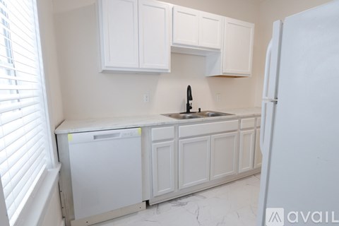 A kitchen with white cabinets and a dishwasher.