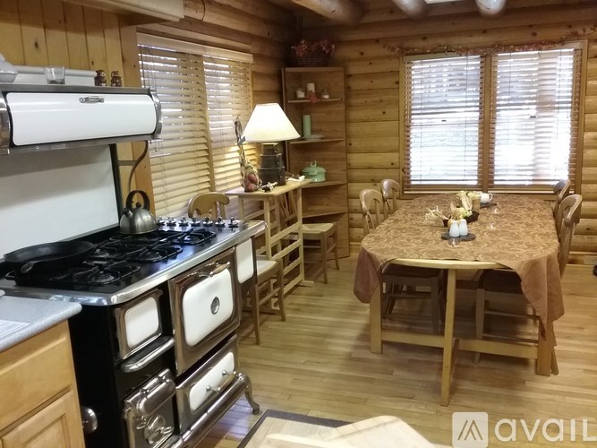 A cozy kitchen with a wood stove and a dining table set for two.