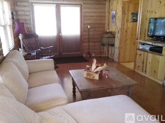 A living room with a couch, chair, and television.