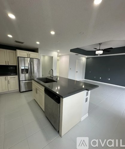 A kitchen with white cabinets and a black countertop.