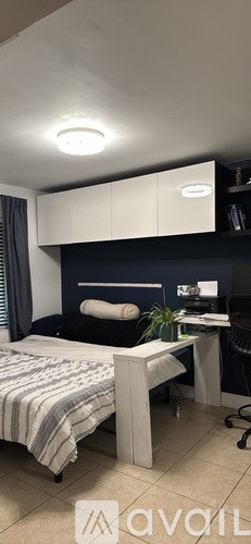 A bedroom with a bed, desk, and chair.