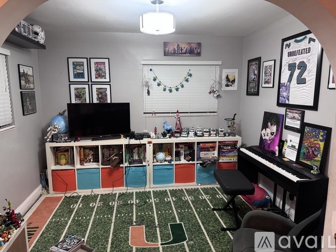 A room with a football field carpet and a TV.
