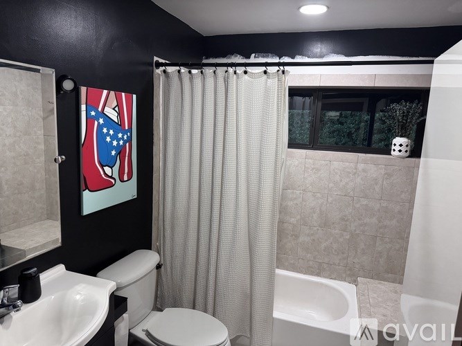 A bathroom with a toilet, sink, and shower.