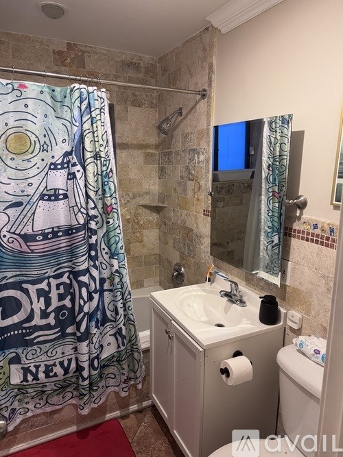 A bathroom with a shower curtain that has a design on it.