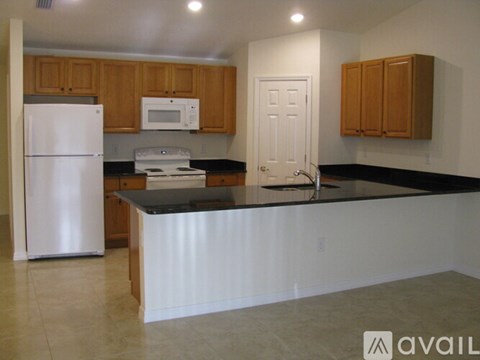A kitchen with a white refrigerator and a white microwave.