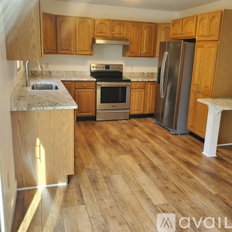 A kitchen with wooden cabinets and a marble countertop.