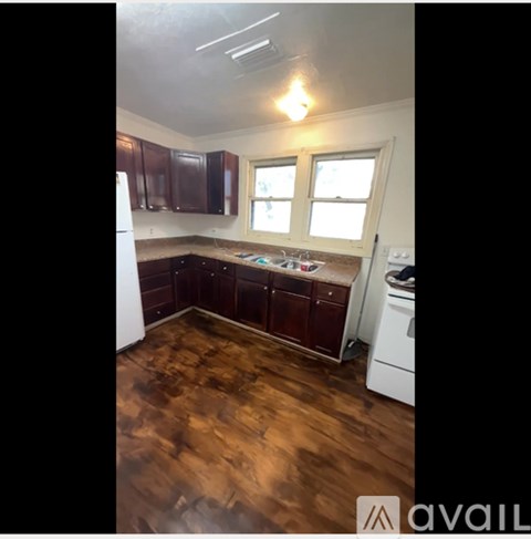 A kitchen with brown cabinets and a white refrigerator.