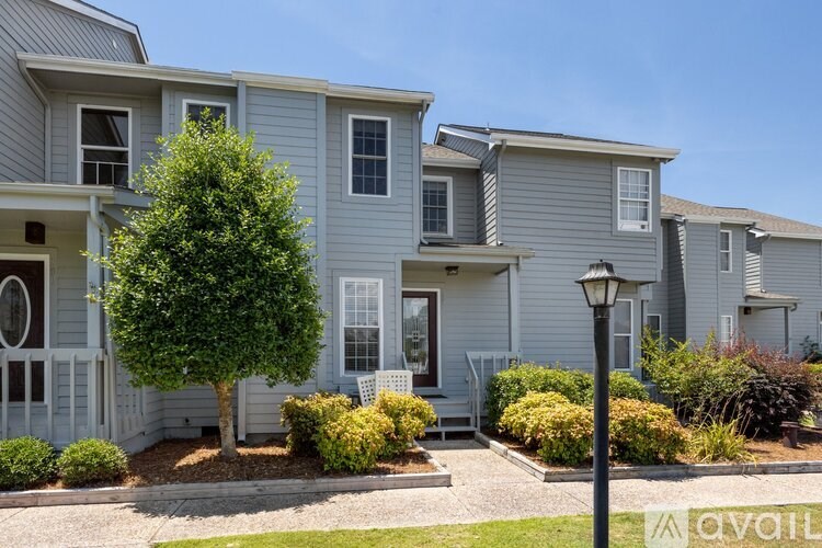 A row of houses with a tree in front of the first one.