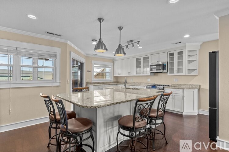 A kitchen with a marble island and chairs.