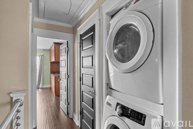 A washing machine is in a narrow hallway.