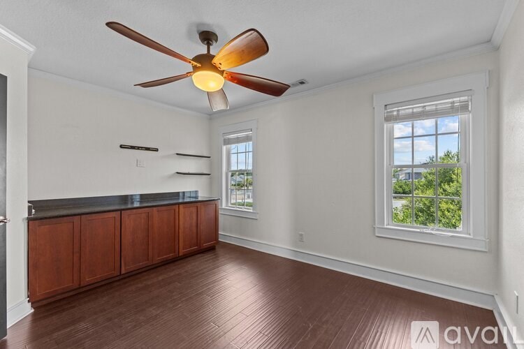 A room with a ceiling fan and a window.