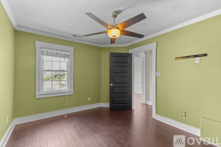 A room with a ceiling fan and a window.
