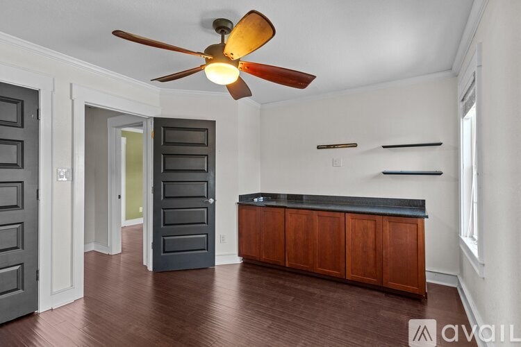 A room with a ceiling fan and a cabinet.