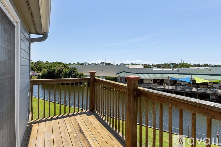 A balcony with a wooden floor and a railing overlooking a body of water.