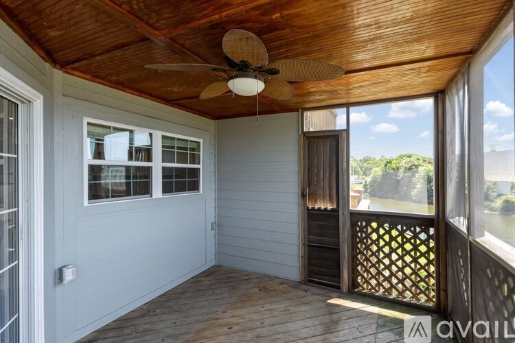 A balcony with a ceiling fan and sliding glass doors.