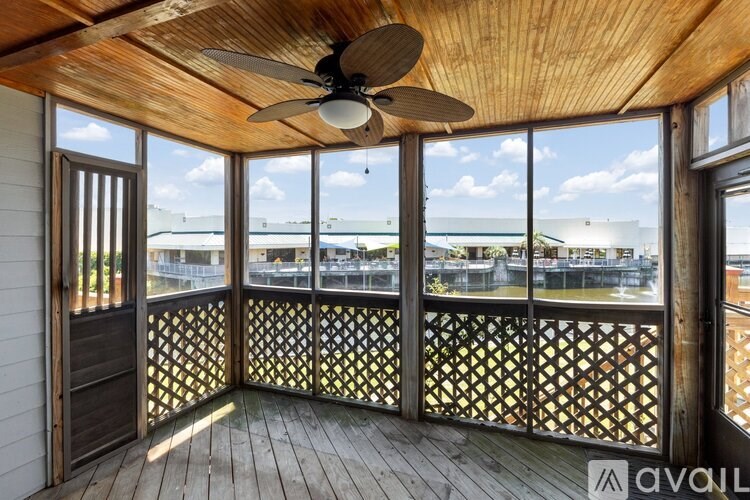 A balcony with a ceiling fan and a lattice railing.