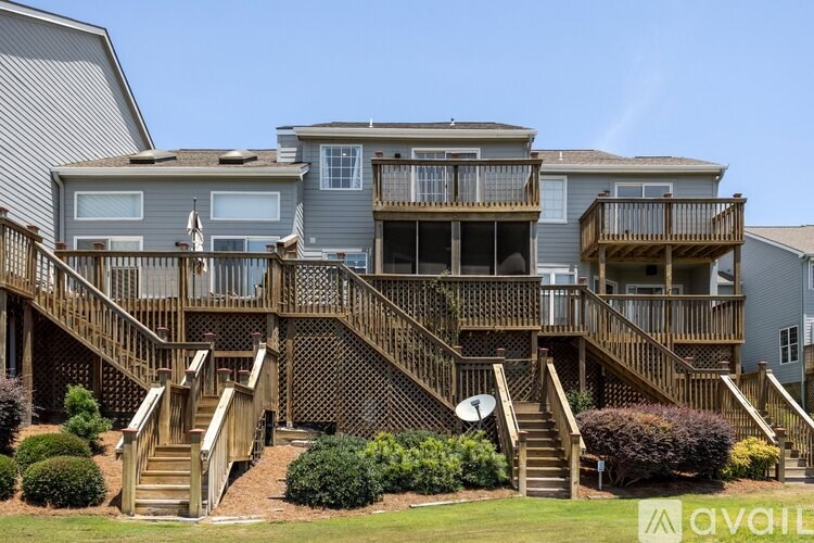 A large house with a wooden deck and stairs leading to the second floor.