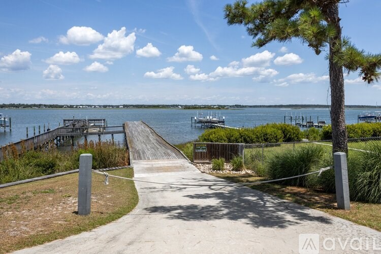 A pathway leads to a dock with a boat in the water.